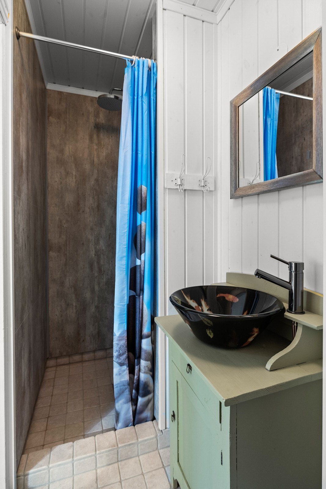 Badet har dusjnisje, servant samt veggmontert toalett Galleribilde