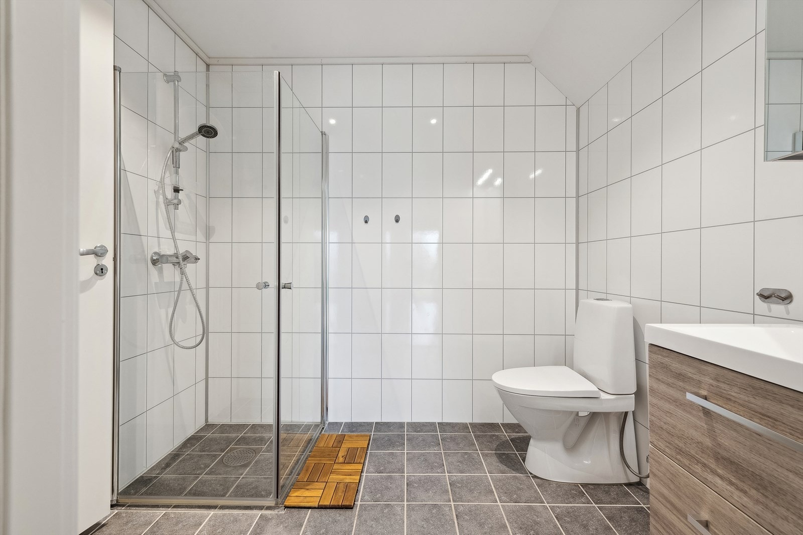 Badet i underetasjen har baderomsplater på veggene og fliser på gulvet. Galleribilde