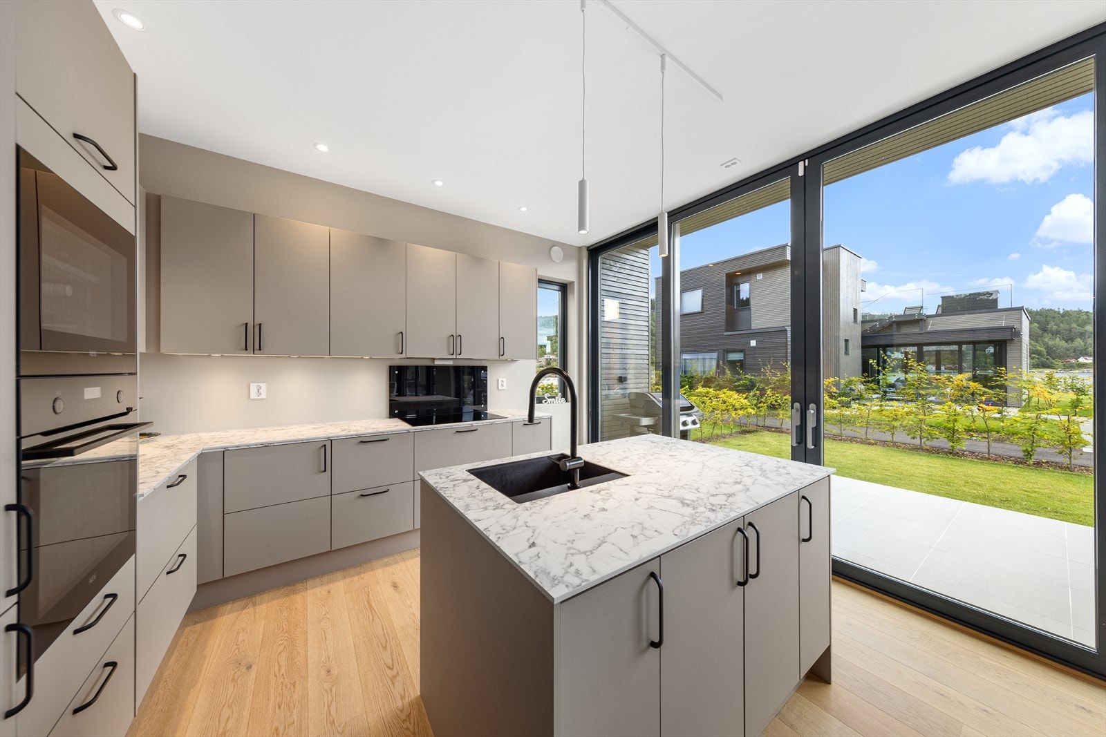 Lekkert kjøkken med alt av hvitevarer: Kombinert kjøl/frys, platetopp m. avtrekk, komfyr, oppvaskmaskin og vinskap. Galleribilde