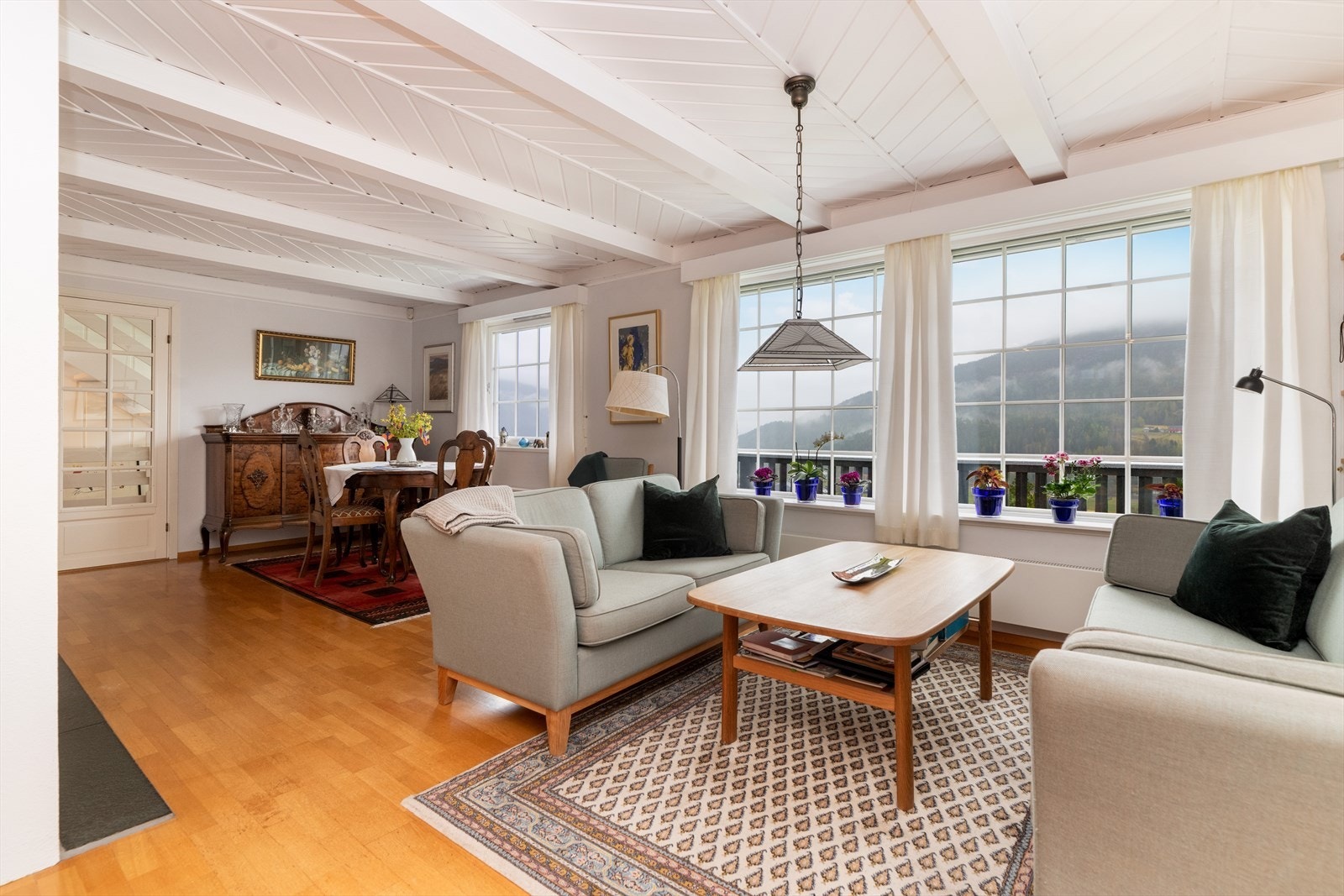 Stuen i hovedetasjen er en fin vinkelstue med gode veggflater som gir fin plass til møblering. Det er gode vindusflater både mot sør, vest og nord, som gir fint lysinnslipp og et vakkert utsyn til de vakre områdene rundt eiendommen. Galleribilde