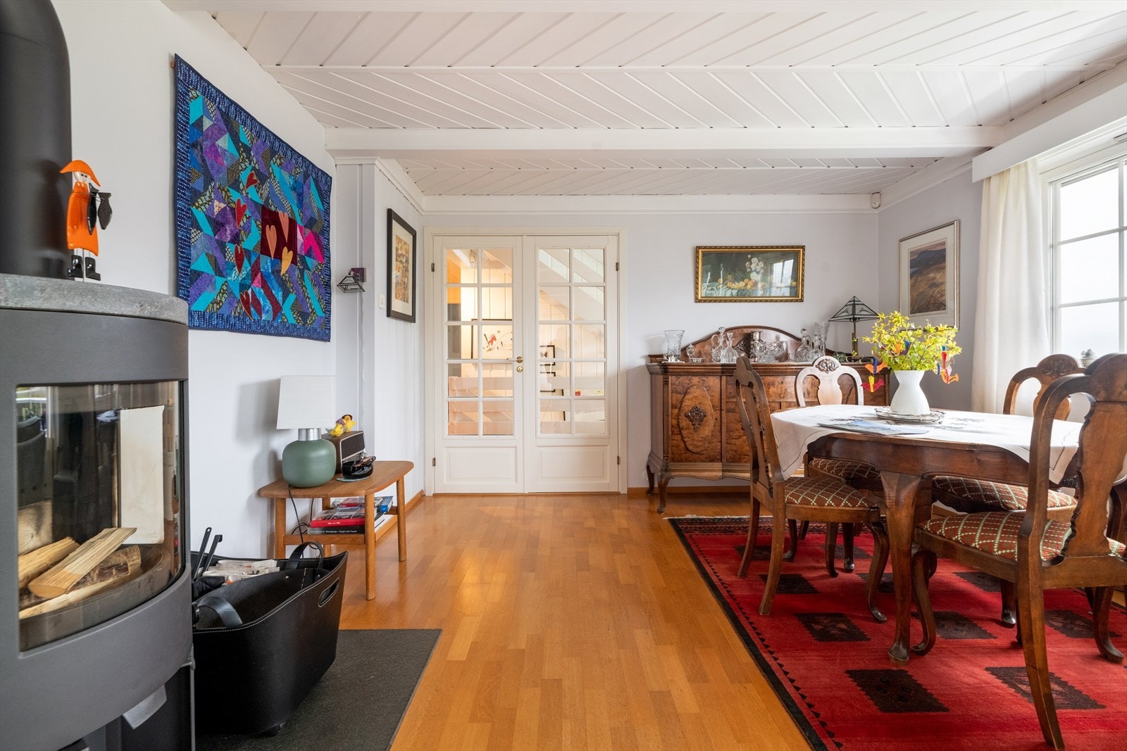 Sentralt i rommet er det satt inn en lekker peisovn med glassflate som gir god oppvarming på kalde dager, i tillegg til at det er radiatorer tilknyttet den vannbårne varmen i rommet. Galleribilde