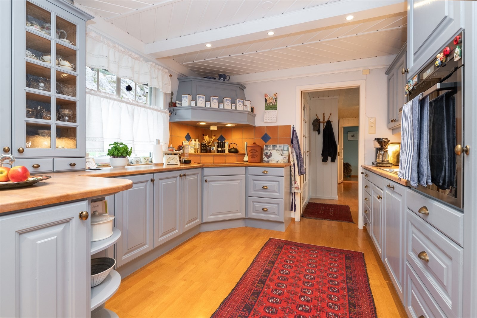 Kjøkkenet er innredet med heltre innredning med profilerte fronter fra 2000. Innredningen er malt i en pen fargetone, har gode arbeidsflater på heltre benkeplate og god skap- og skuffplass. Galleribilde