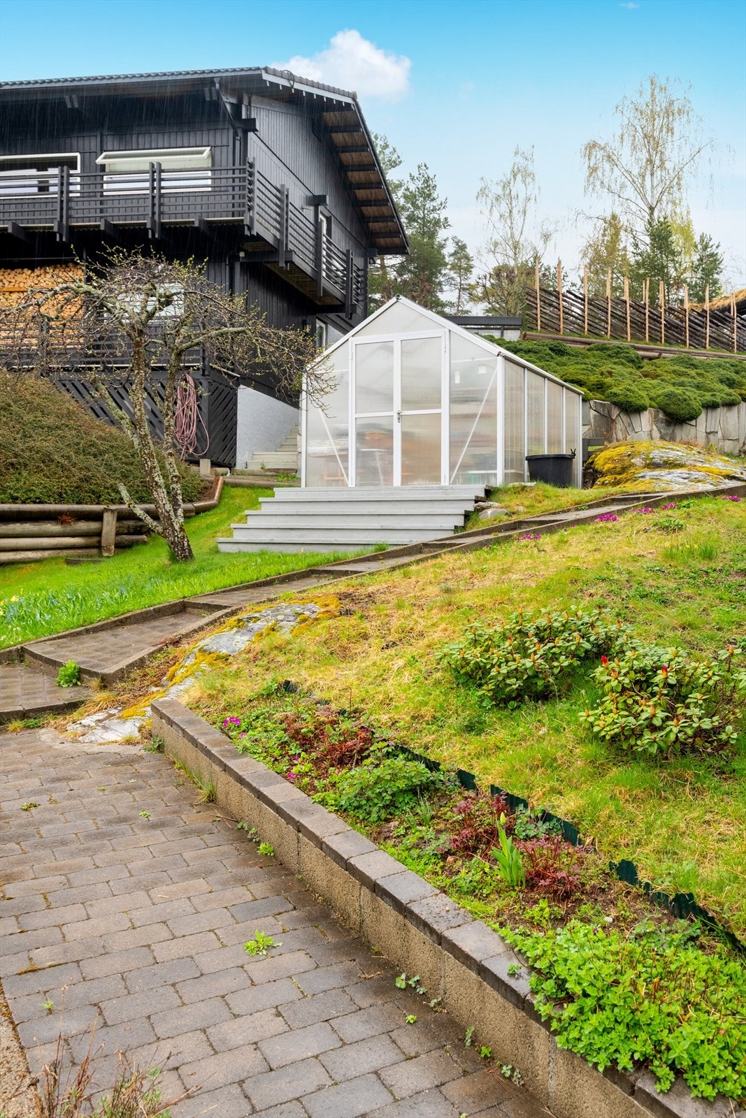 Tomten er generelt pent opparbeidet med nydelige blomsterbed, prydbusker, trær og har noe fjell i dagen, som gir en variert og fin tomt. Drivhus i hagen fra 2007. Galleribilde
