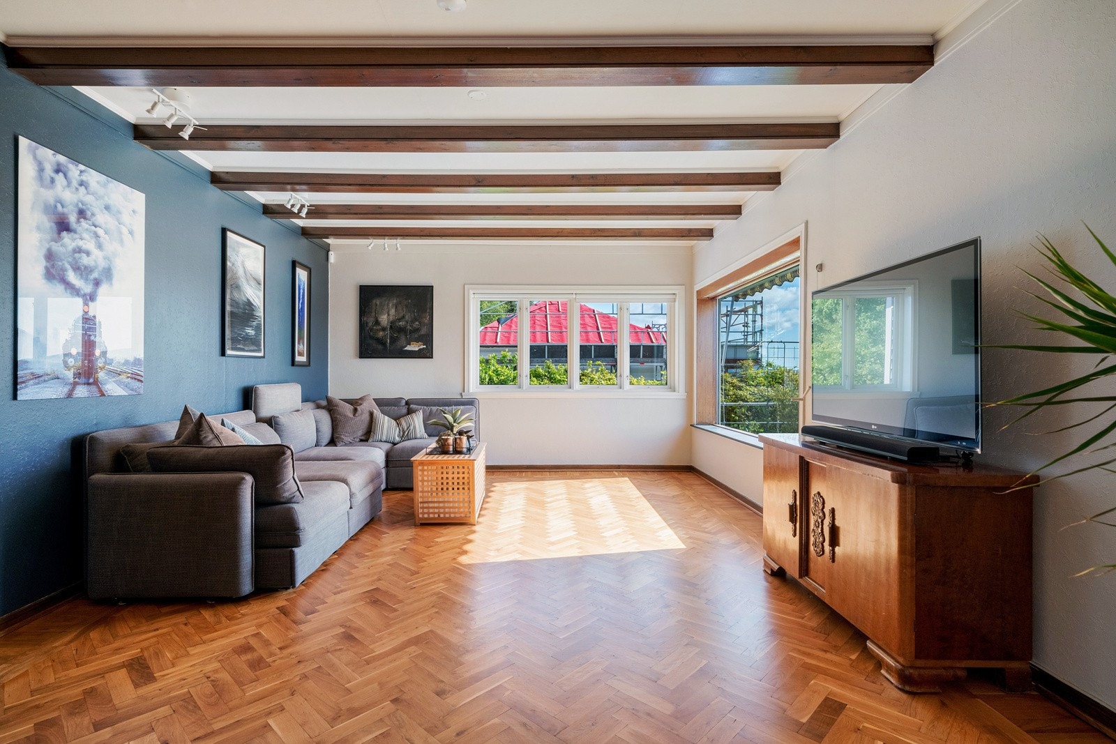 Stuen fremstår lys og moderne med fiskebeinsmønstret eikeparkett Galleribilde