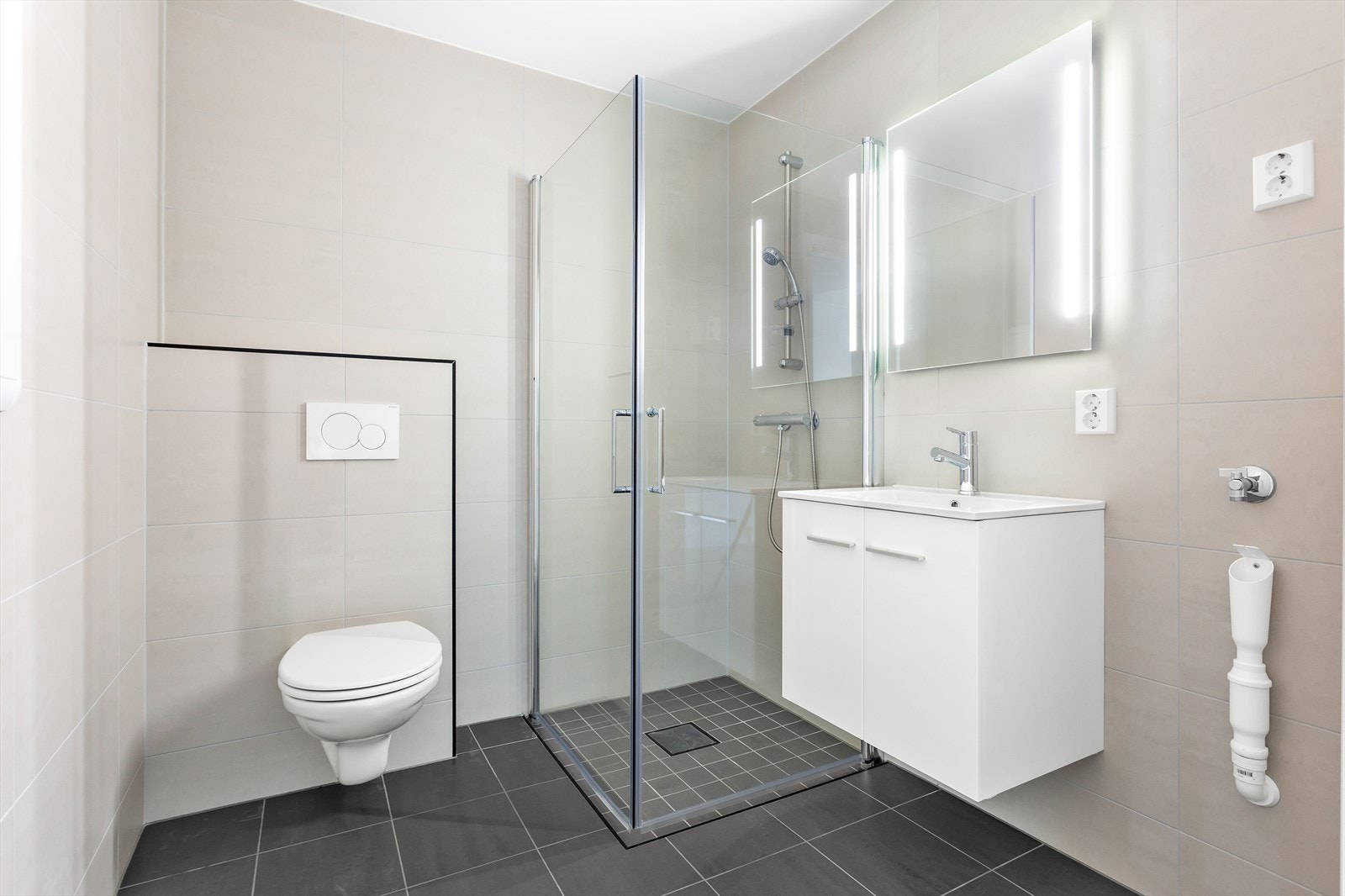 Badet er helfliset og stilrent designet - og har lun gulvvarme. Galleribilde