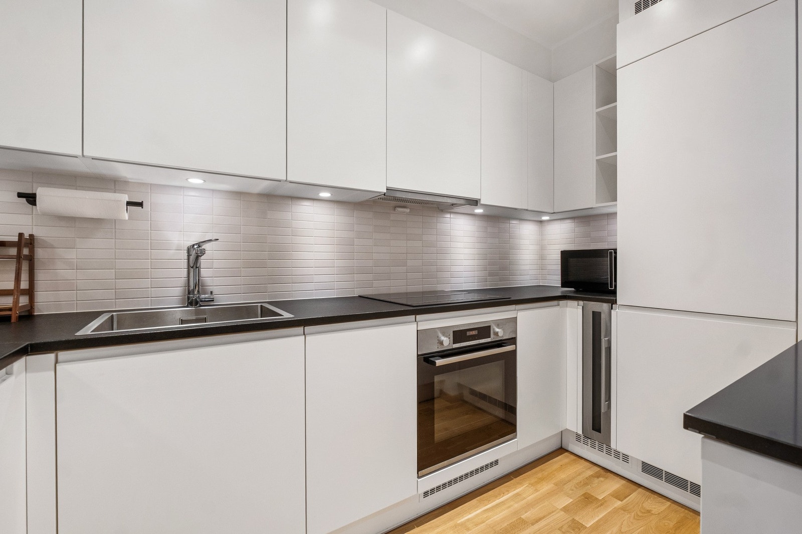 De moderne frontene og lyse overflatene skaper en frisk og trivelig atmosfære, perfekt for både raske måltider og lengre matlagingsøkter. Galleribilde