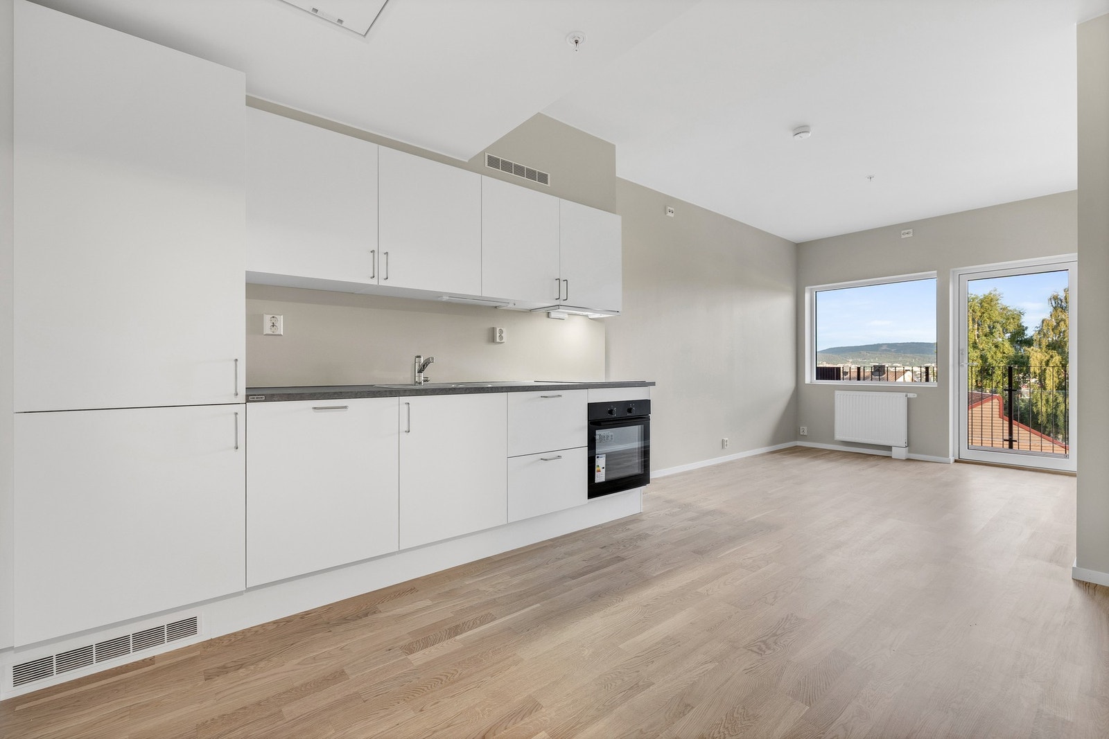 Oppholdsrom med åpen stue- og kjøkkenløsning og store vindusflater. Utgang til en østvendt balkong gir flott utsikt og en luftig atmosfære. Galleribilde