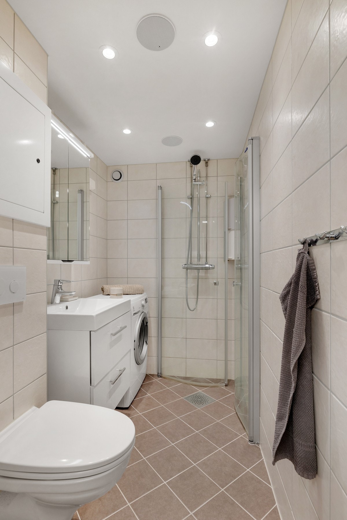 Badet har vegghengt toalett med innebygd sisterne kasse. Opplegg for vaskemaskin. Galleribilde