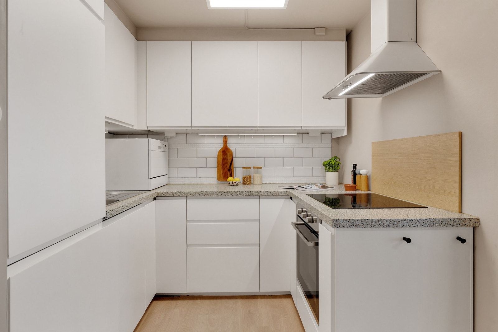 Kjøkkenet har moderne, glatte fronter og laminert benkeplate med integrert kjøkkenkum. Galleribilde
