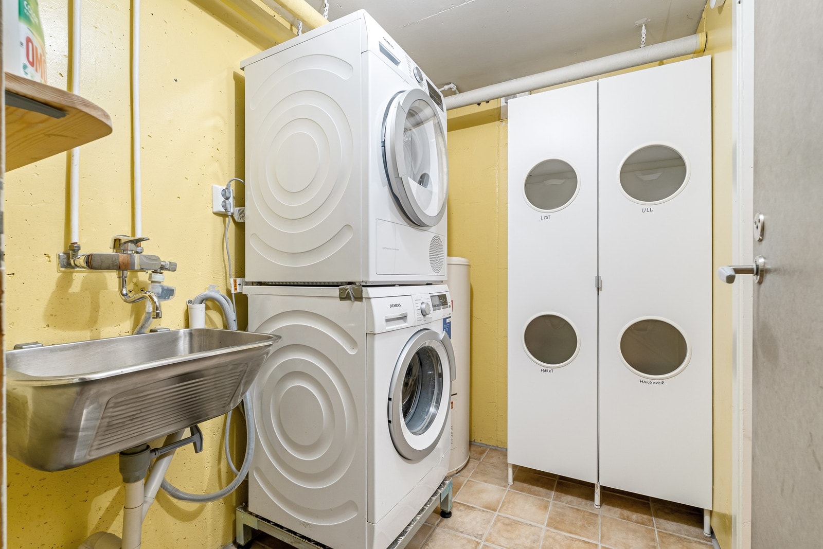 Separat vaskerom utstyrt med flislagt gulv, noe som gir både god slitestyrke og enkel rengjøring. Galleribilde