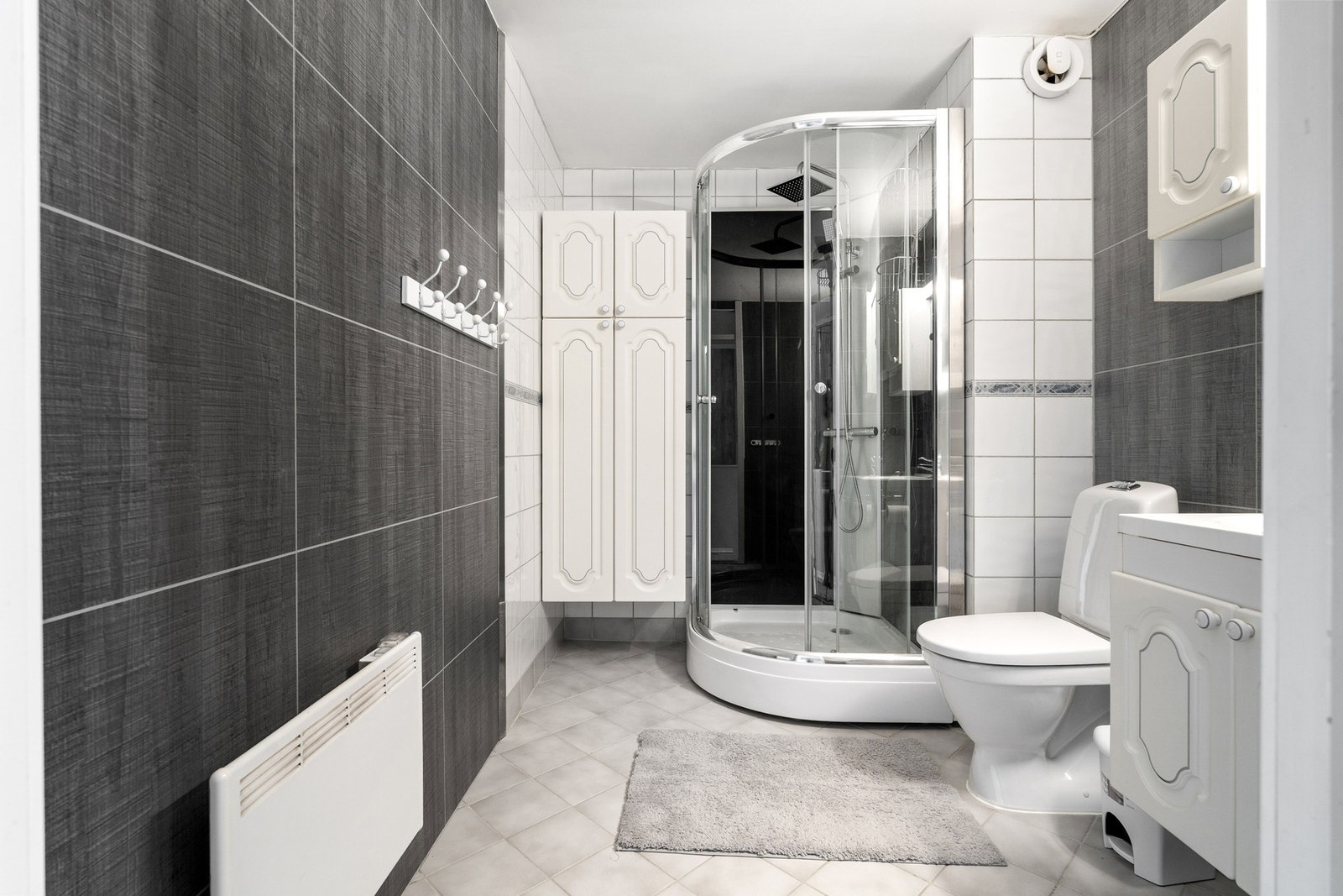 Badet er utsyrt med dusjkabinett og ytterligere skap for oppbevaring. Galleribilde