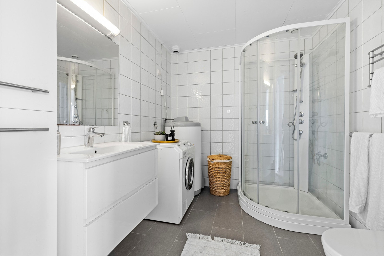 Pent, flislagt bad med opplegg for vaskemaskin. Galleribilde