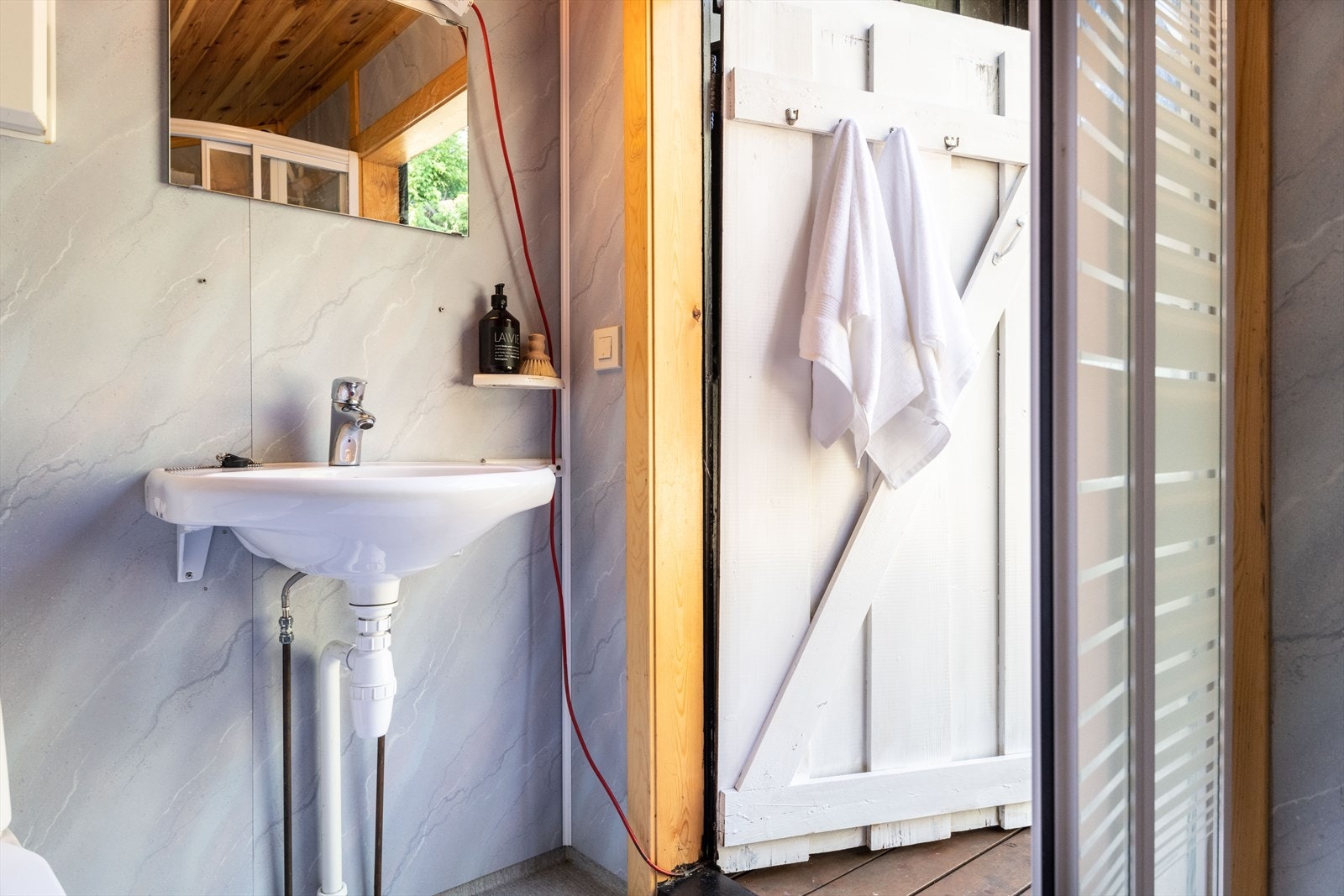 Baderommet er svært enkelt og har adkomst fra utsiden - med våtromspanel og linoleumsgulv, toalett, vask og dusjkabinett. Galleribilde