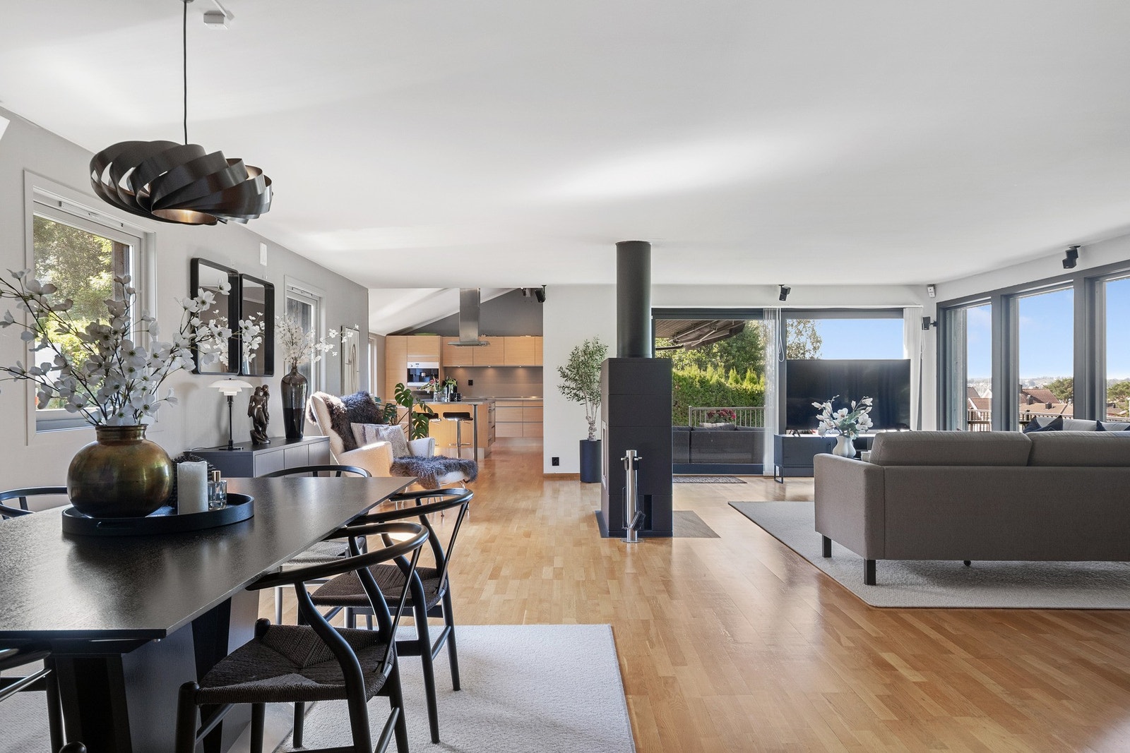 Stuen ligger i åpen løsning med kjøkkenet, og sammen danner de et stilfullt og innbydende allrom som dekker store deler av første etasje. Galleribilde