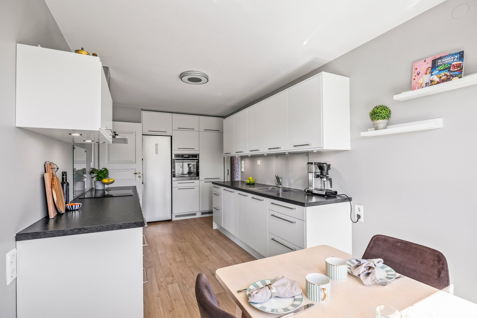 Kjøkkenet har god skap- og benkeplass, laminatfronter, benkeplate i laminat og glassplate over kjøkkenbenken. Galleribilde