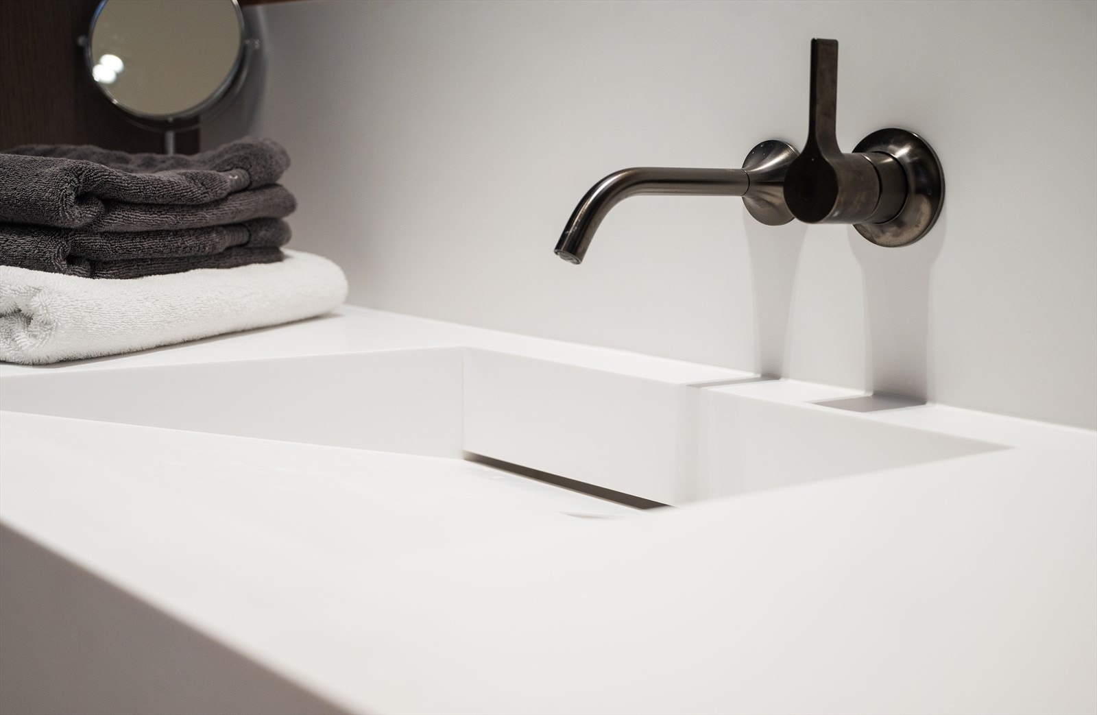 Armaturer fra Dornbracht i dark platinum. Spesiallaget vask i Dupont, Glacier White integrert i benkeplate. Galleribilde