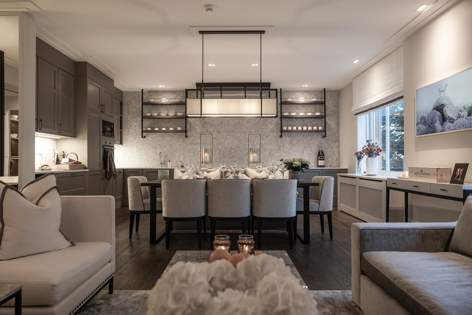 Snekkerbygget kjøkken med integrerte hvitevarer og utpreget bruk av marmorfliser. Galleribilde