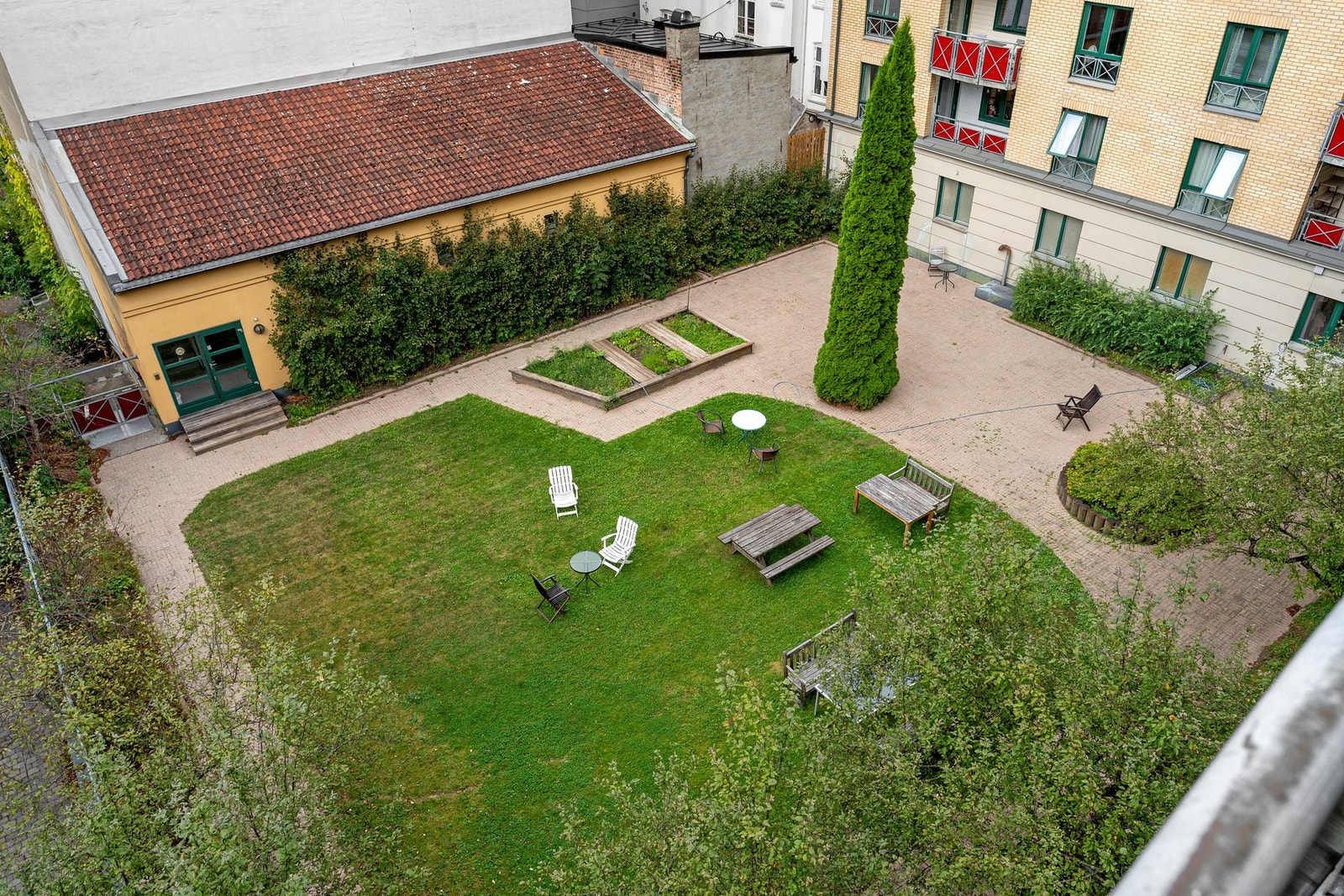 Solrik bakhage med stor plen, prydbusker, sittegrupper og grillplass. Galleribilde