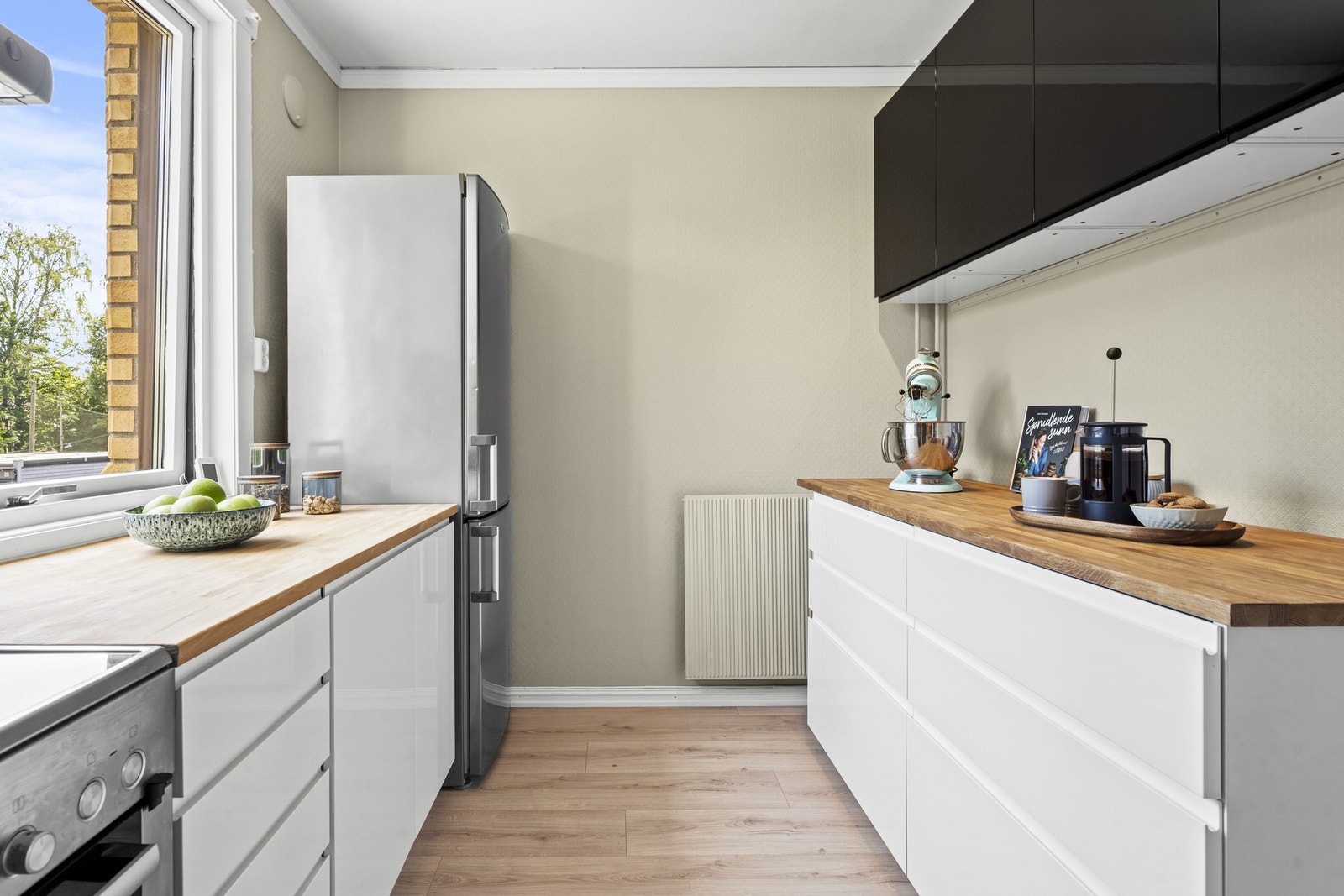 Kjøkkenets utforming byr på godt med skap- og benkeplass fra flere sider. Galleribilde