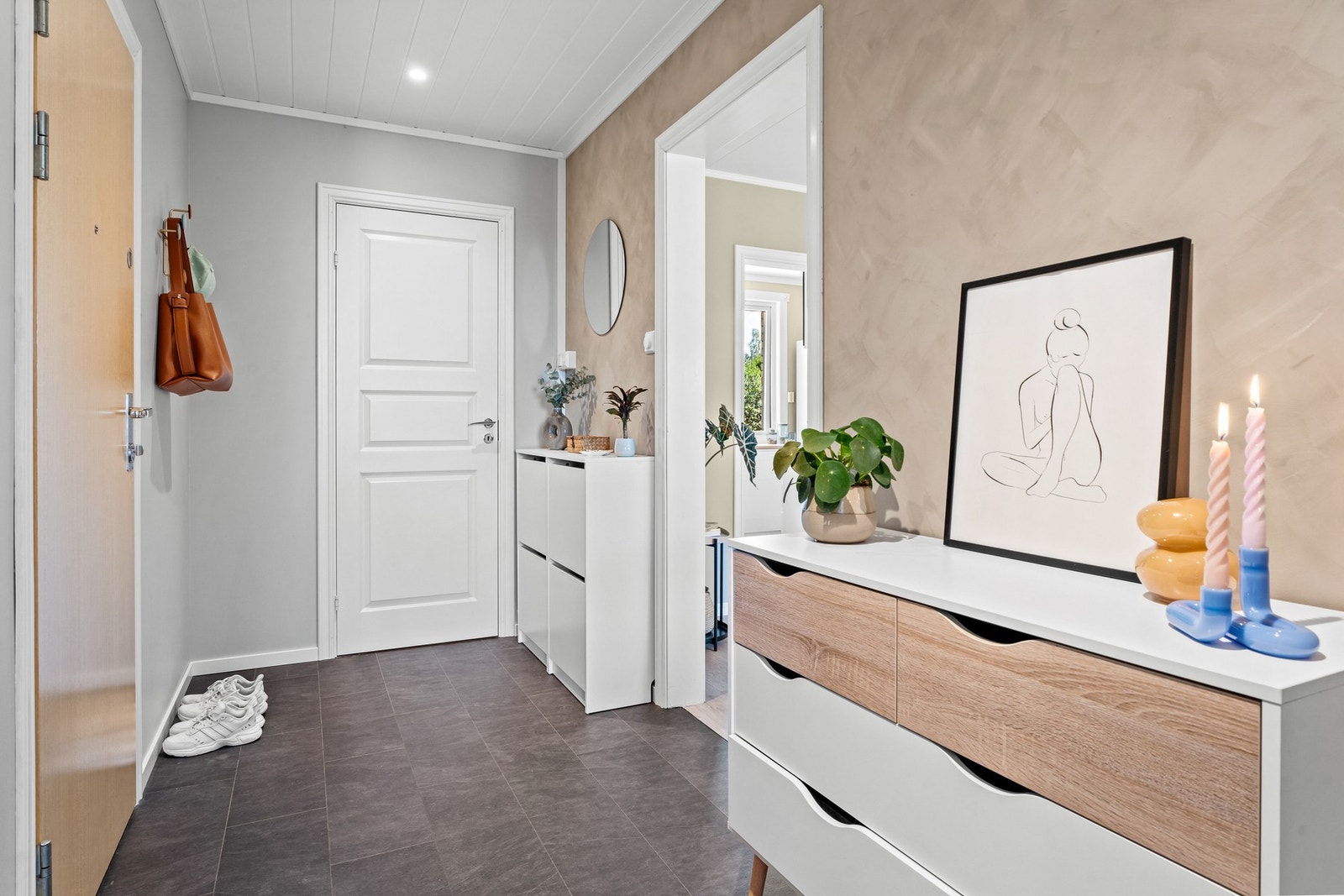 Tiltalende og hyggelig entré som gir et godt førsteinntrykk av boligen. Videre er det godt med plass til oppbevaringsmøblement. Galleribilde