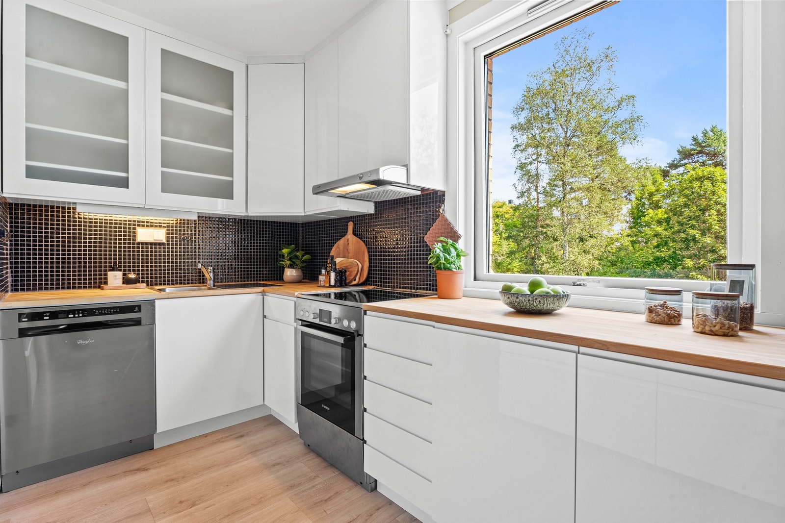 Stilrent kjøkkeninnredning med glatte fronter og benkeplate i heltre. Galleribilde