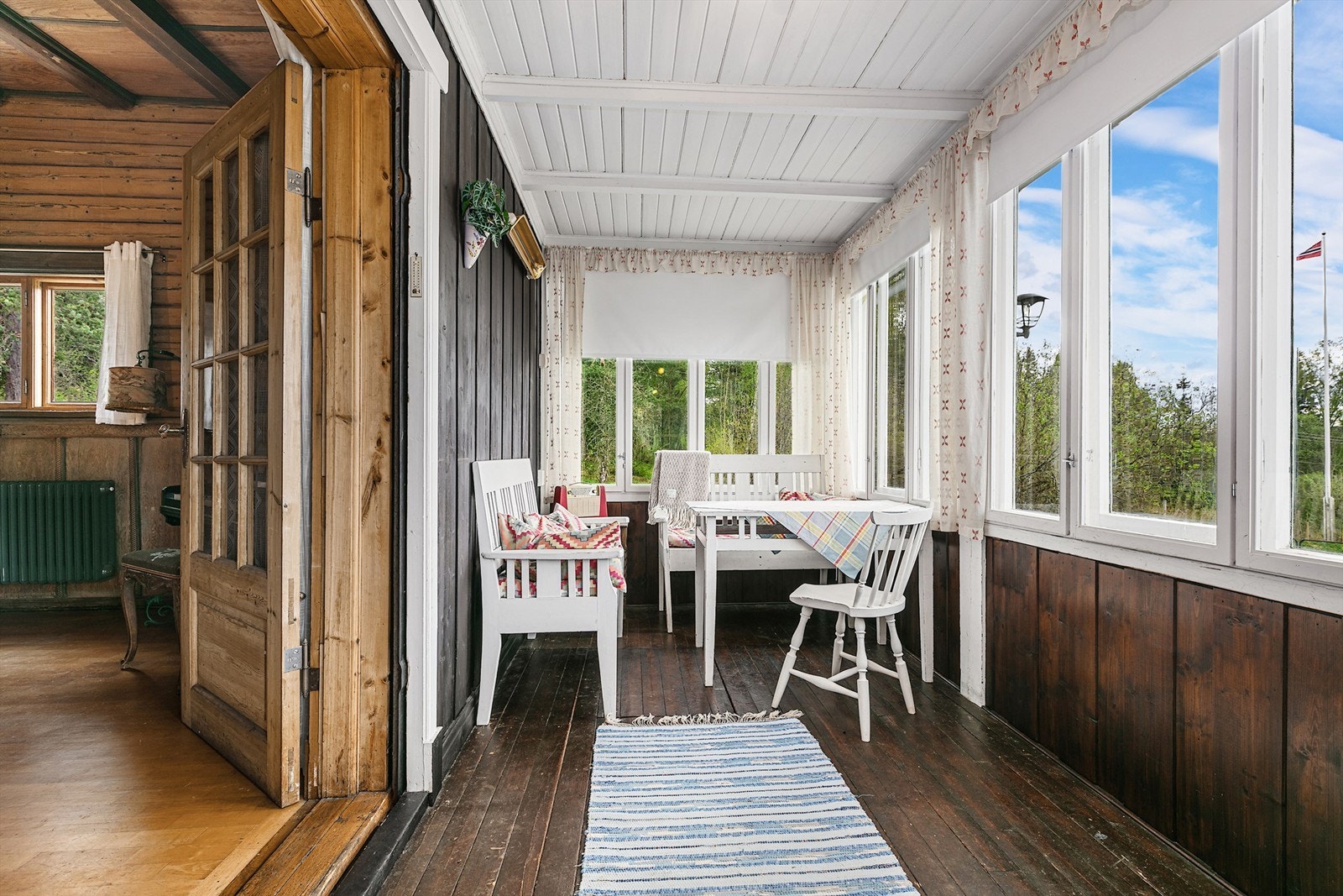 Innglasset terrasse i hovedbygget - et lyst og trivelig oppholdsrom med store vindusflater som slipper inn rikelig med dagslys og gir flott utsyn mot hagen og landskapet. Perfekt til både frokostkaffen og rolige kvelder, uansett vær. Galleribilde