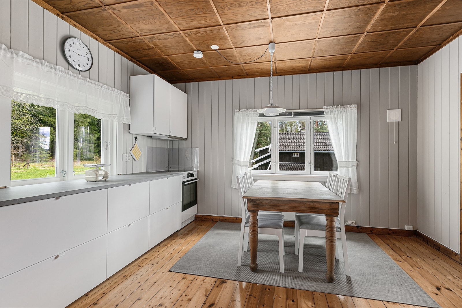 Det romslige kjøkkenet fra 2020 har hvite, glatte fronter, store skuffer, dobbel oppvaskkum og laminert benkeplate. Vedovnen gir en lun atmosfære, og det er god plass til spisebord. Galleribilde