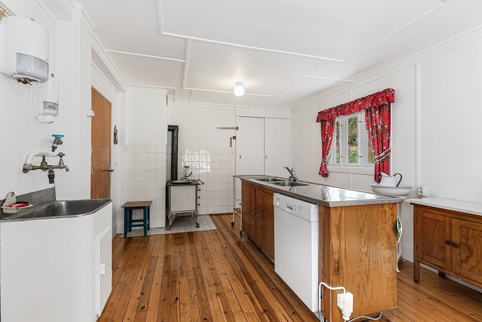 Selve innredningen har glatte heltrefronter, laminert benkeplate og heldekkende beslag med dobbel oppvaskkum.
En vedovn med kokeplate sørger for ekstra varme og hygge. Galleribilde