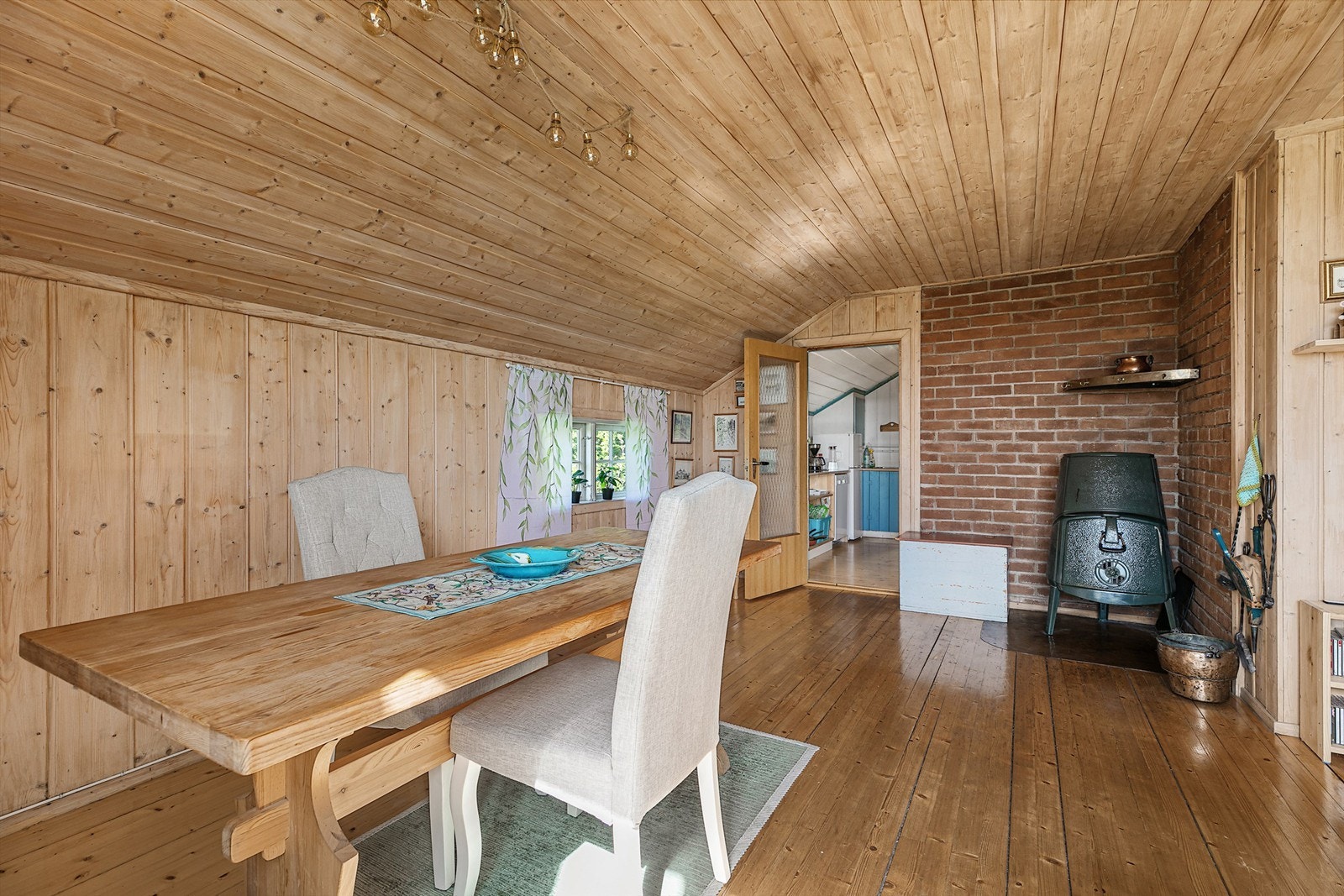 Spisestuedel med plass til stort spisebord. Tretak og vegger i panel skaper en lun og tradisjonell hyttestemning. Galleribilde