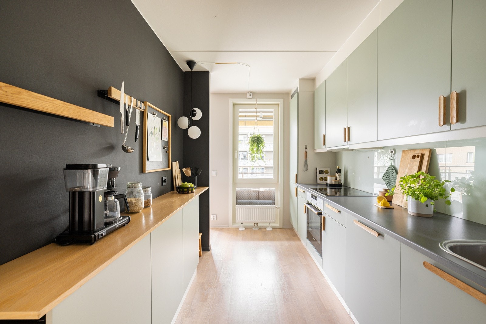 Veggen mot stuen er malt sort, noe som gir en fin kontrast til de lyse, duse og rolige fargene ellers i rommet. Plassen er godt utnyttet med nyere innredning fra 2022. Galleribilde