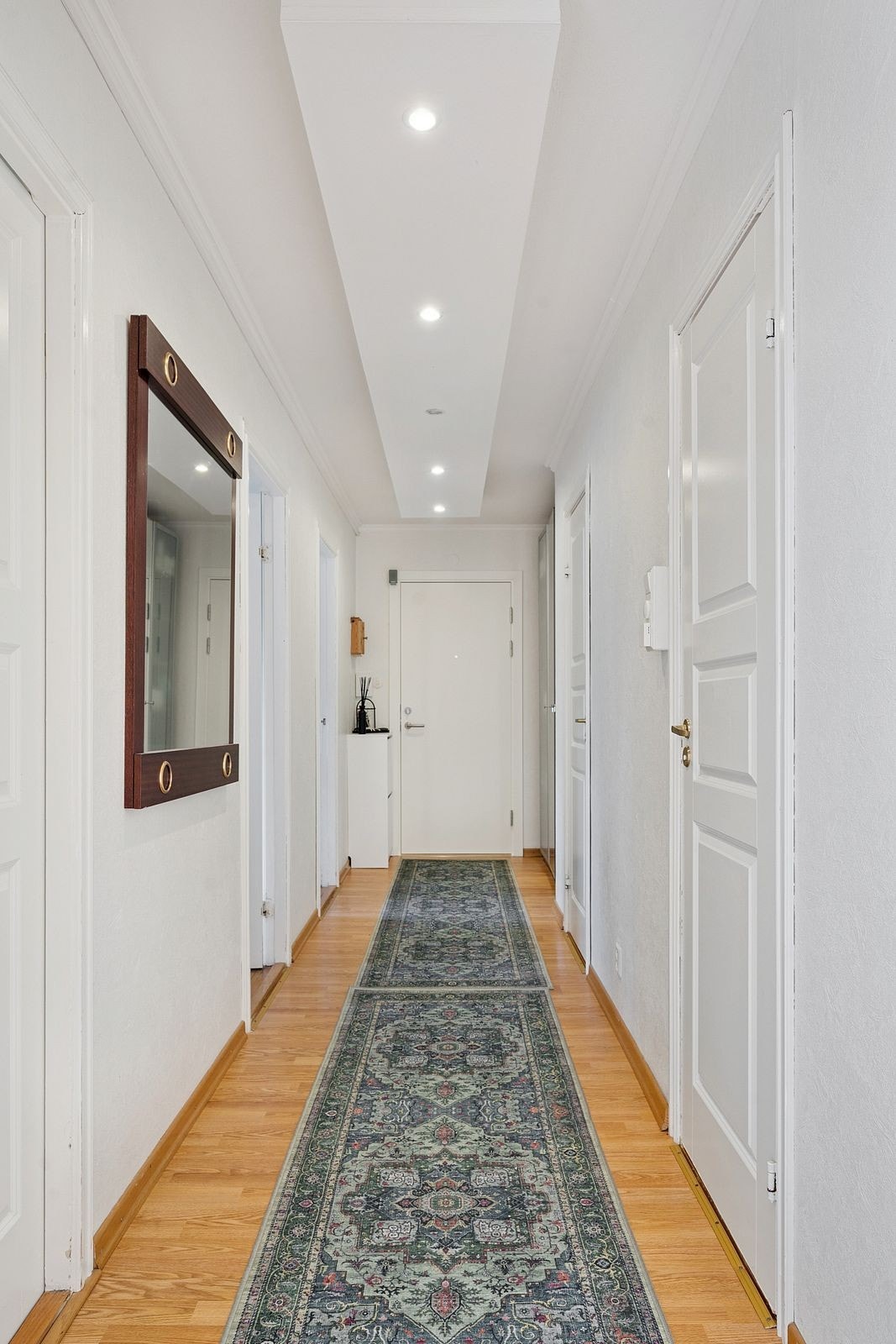 En romslig og oversiktlig entré med naturlig flyt videre inn i boligen. Galleribilde