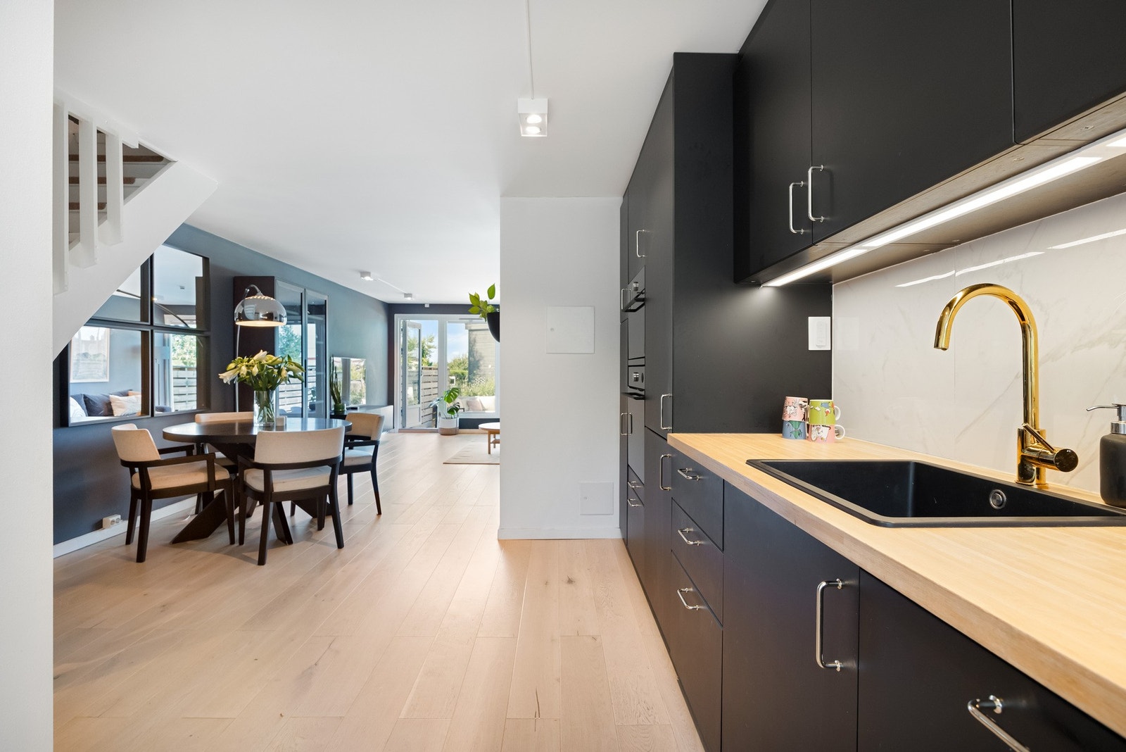 Stilrent og moderne kjøkken fra 2020 med åpen løsning mot stuen, som skaper en luftig og sosial atmosfære. Galleribilde