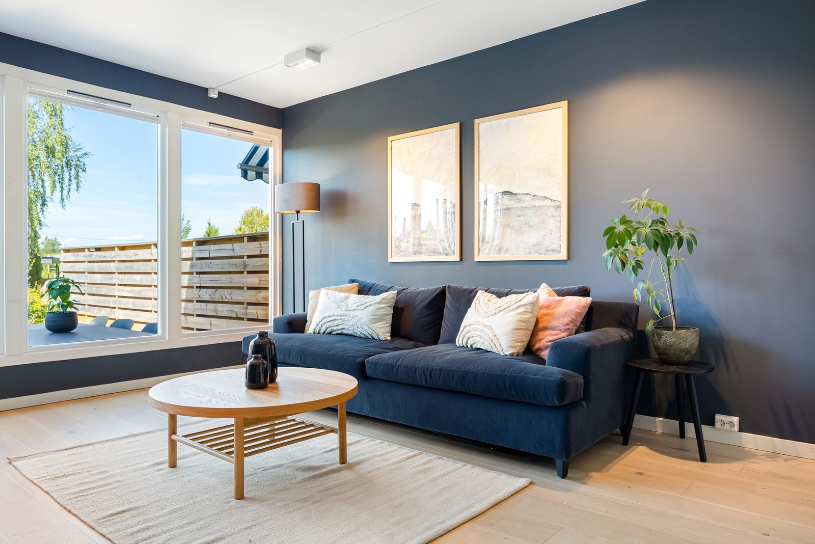 Veggene er malt i en mørk tone som gir rommet dybde og et lunt preg, mens gulvet er dekket med ettstavs parkett. Galleribilde