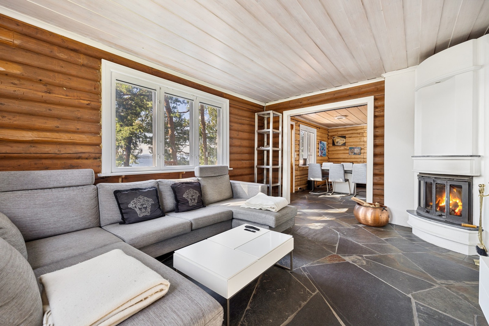 Stue med tradisjonelle materialvalg, med peis og vedovn. Galleribilde