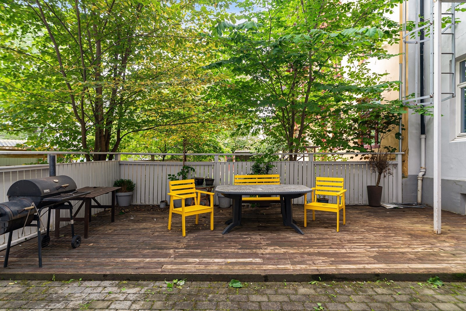 Terrasse med utemøbler og grill i bakgård. Galleribilde