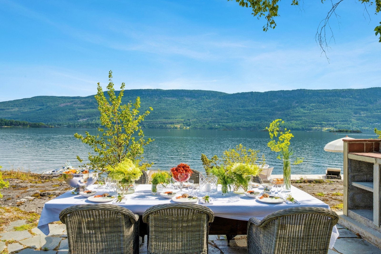 Detaljert utsikt mot vannet, med dekket langbord for uforglemmelige sommermåltider. Galleribilde