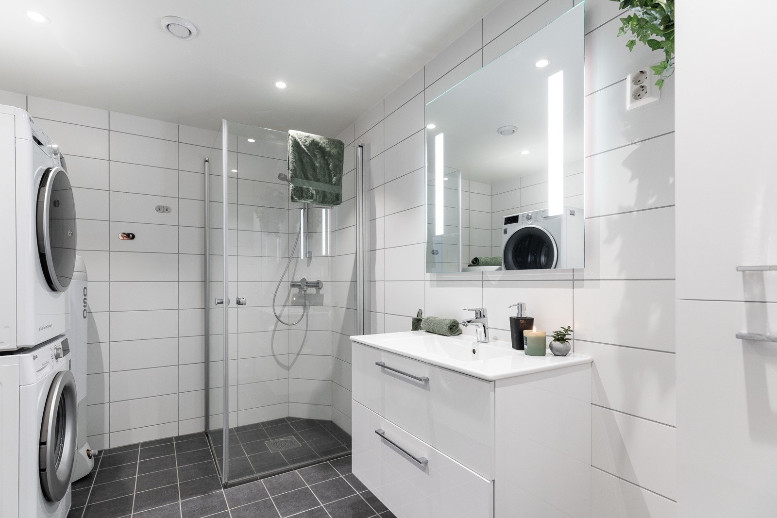 Badet har et delikat uttrykk med mørke gulvfliser og hvite veggfliser for en fin kontrast. Galleribilde
