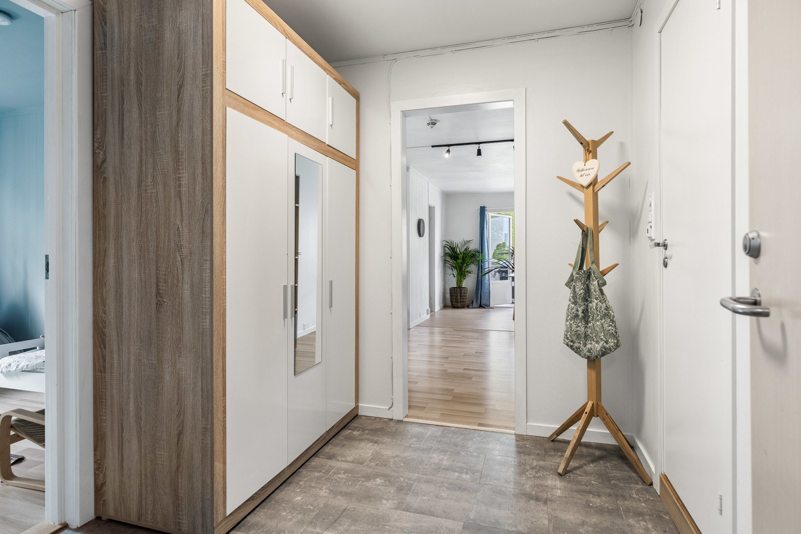 Vel inne er entreen innredet med hvitmalte vegger og flismønstret laminatgulv. Galleribilde