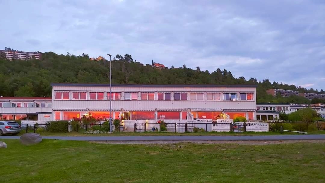 Selgers private bilde. Et fredelig bomiljø hvor solnedgangen speiler seg i vinduene. Galleribilde