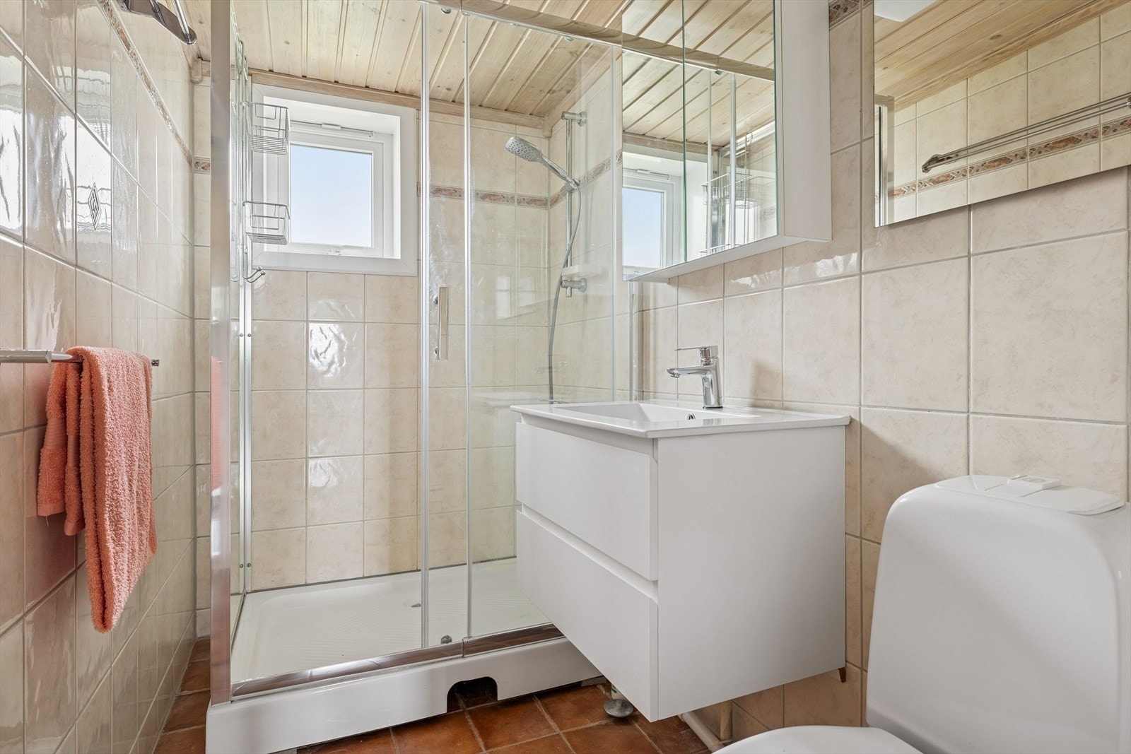 Boligens bad, innredning med nedfelt servant, gulvfestet toalett og dusjlinje. Galleribilde