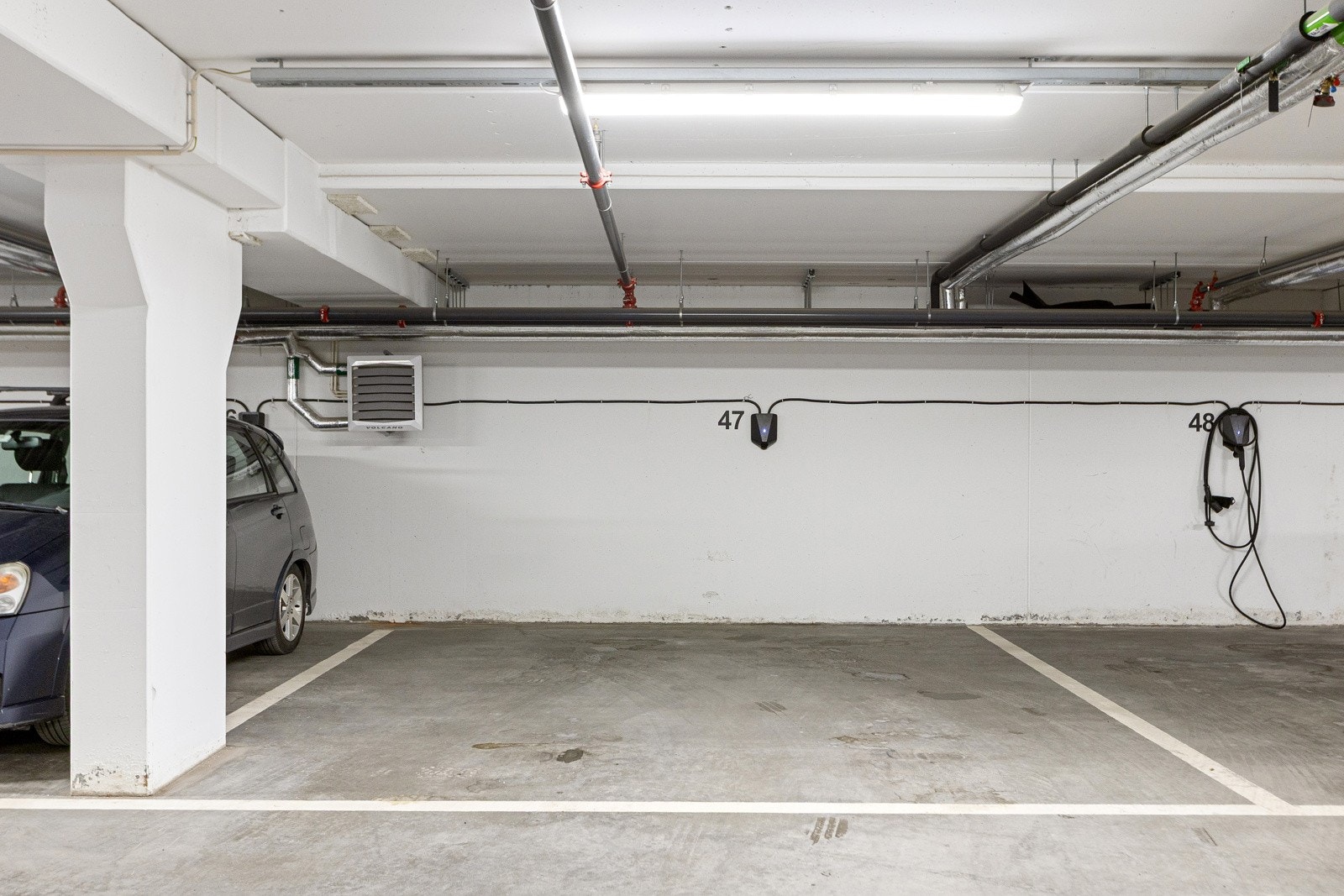 Ekstra bred (ca 4m) parkeringsplass med elbillader i felles garasjeanlegg. Galleribilde