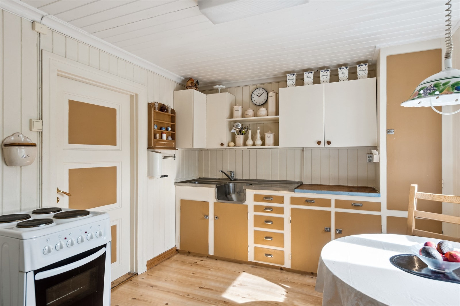 Eldre kjøkken innredet med over- og underskap på én vegg. Galleribilde