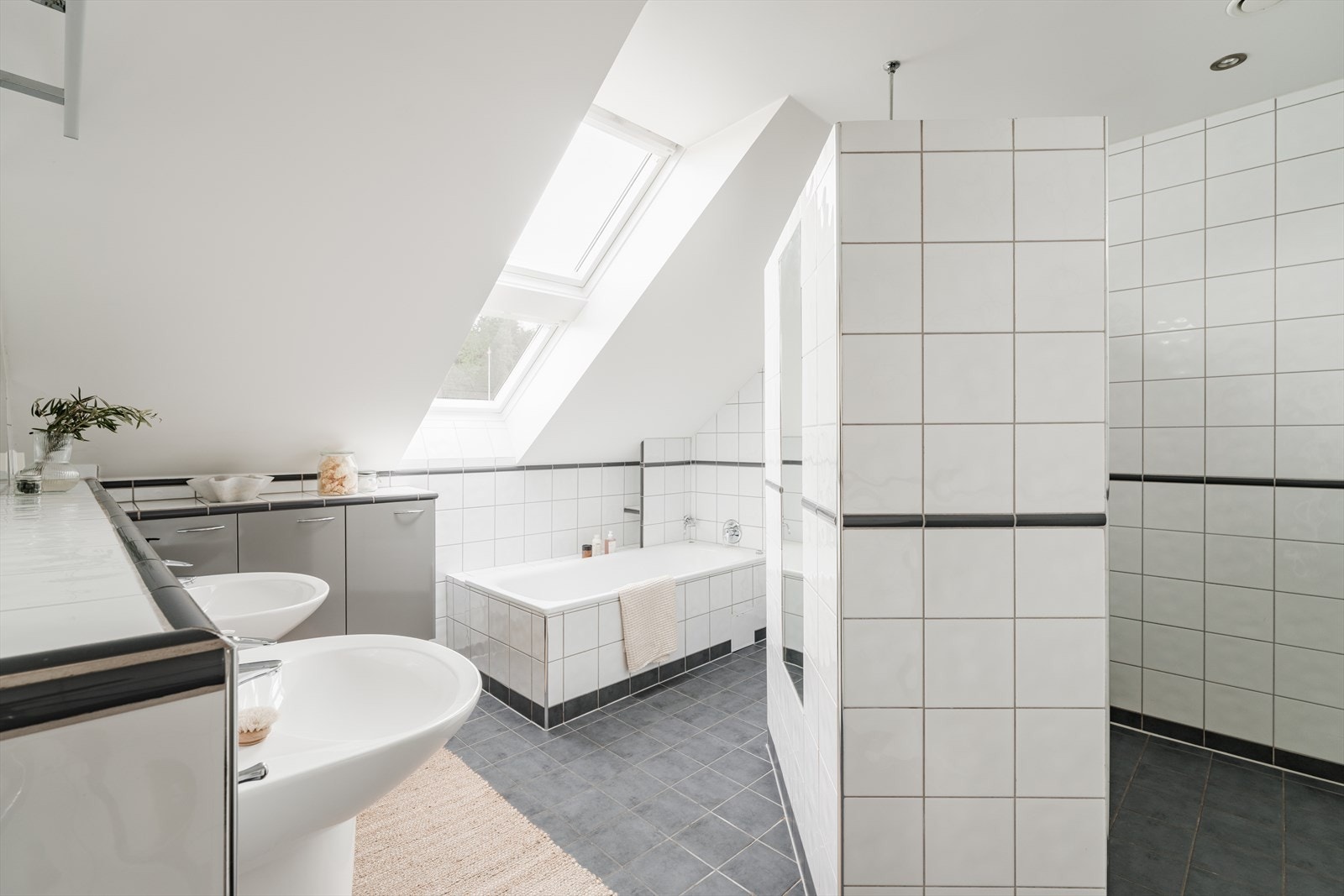 Stilfullt baderom med to servanter, veggmontert toalett, innmurt badekar og dusjhjørne. Galleribilde