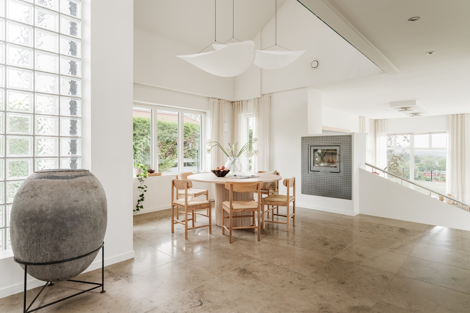 Store vindusflater og imponerende takhøyde gir en luftig atmosfære, mens peisen skaper lun stemning. Galleribilde