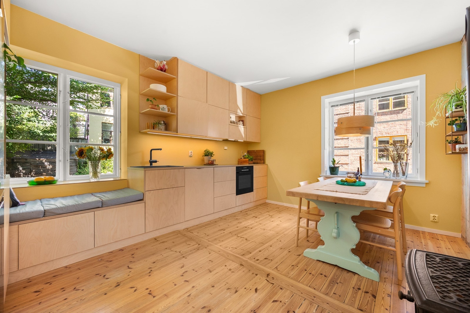 Lyst og lekkert kjøkken som ligger delvis skjermet fra resten av leiligheten. Galleribilde