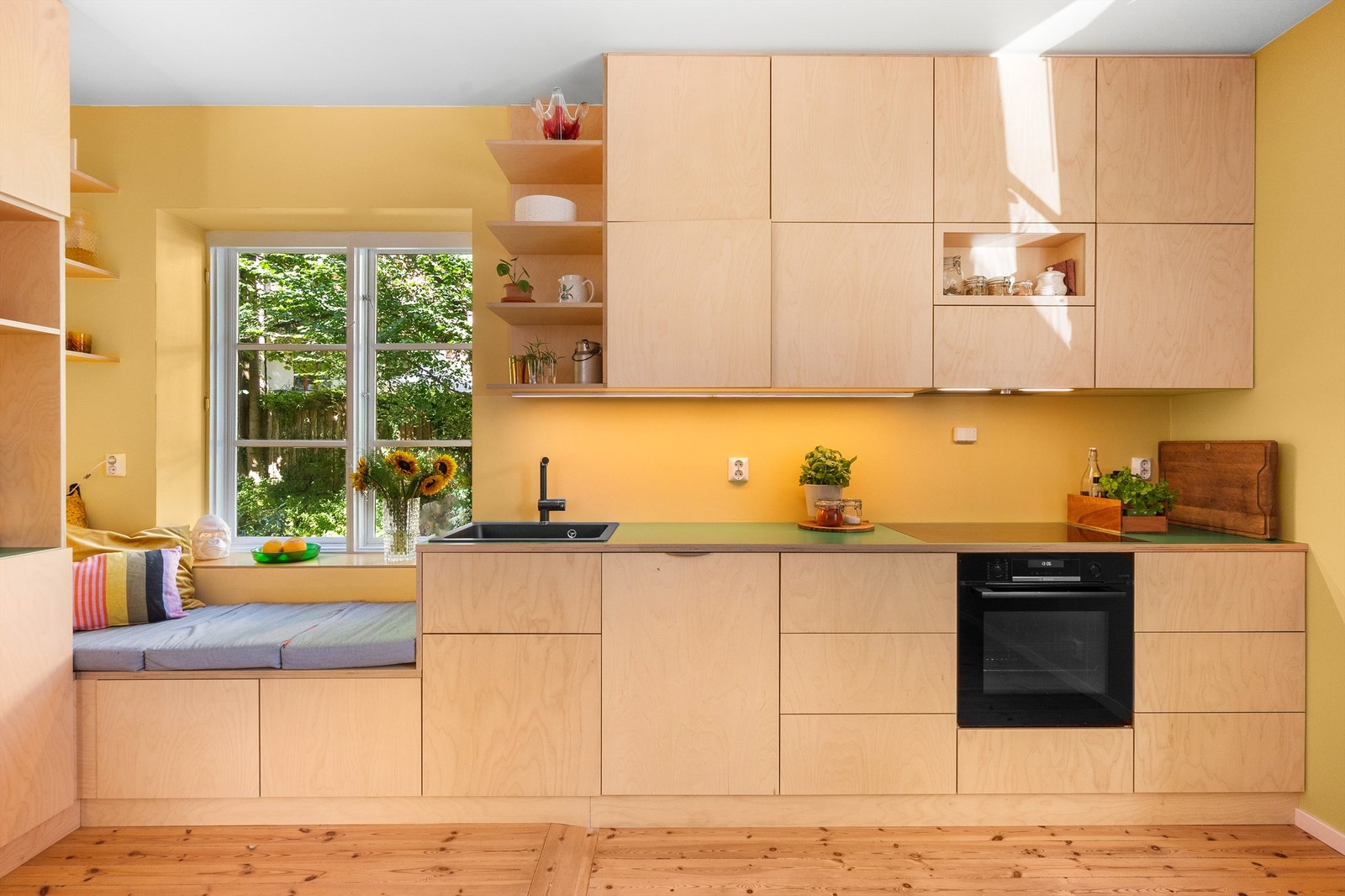 Kjøkkenet har godt med skapplass i takhøye overskap og romslige innredningsmøbler. Innredningen har glatte skapfronter med heltre benkeplate og nedfelt vaskekum. Videre er det belysning over benkeplaten. Galleribilde