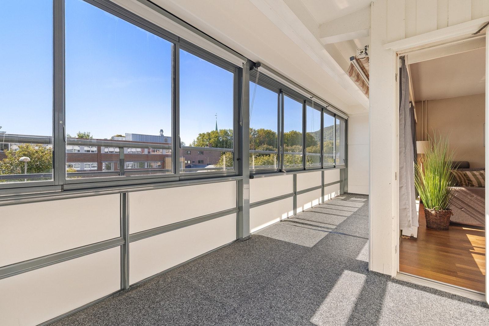 Balkongen har gulvoverflate belagt med teppebelegg, og rekkverk av metall, plateemner og skyvbare glassfelter Galleribilde