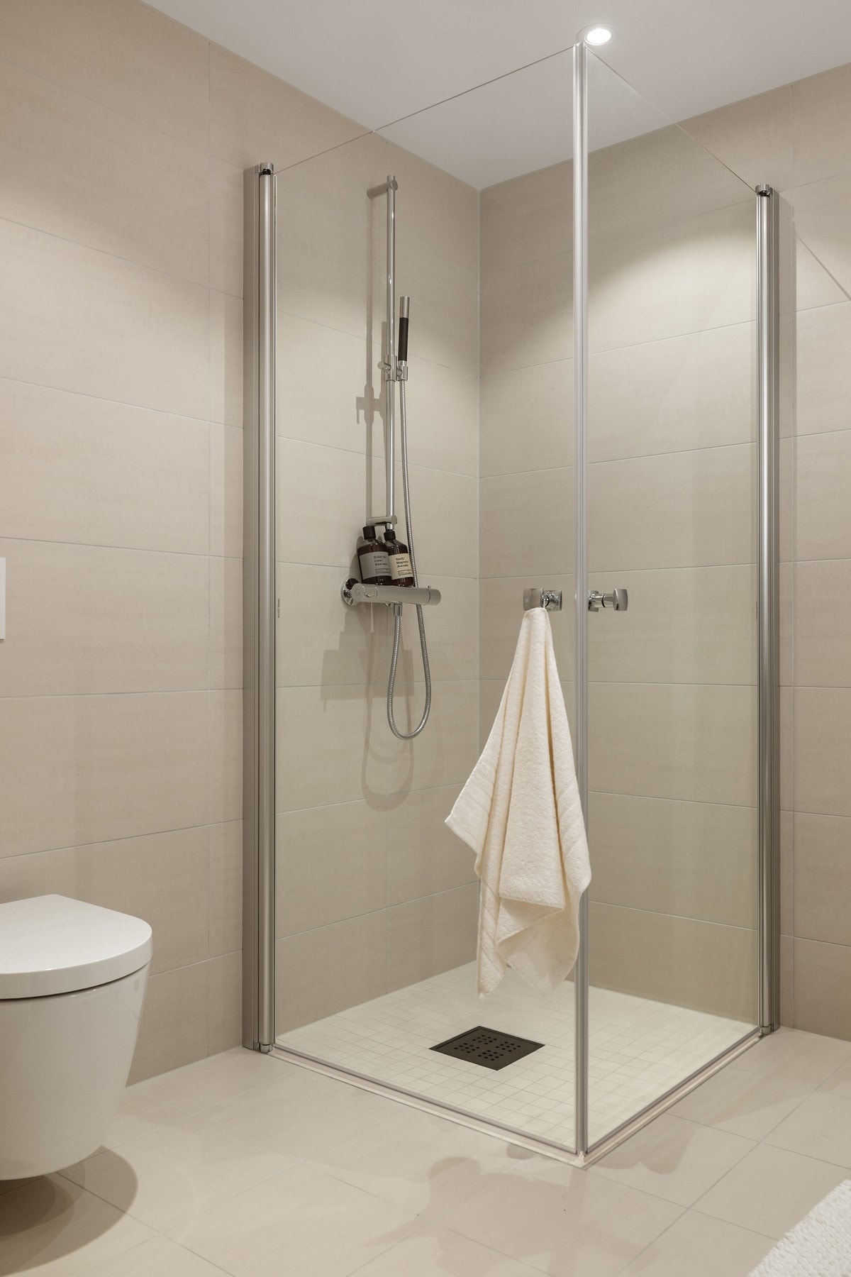 Romslig dusjsone bak innfellbare dører i glass. Galleribilde