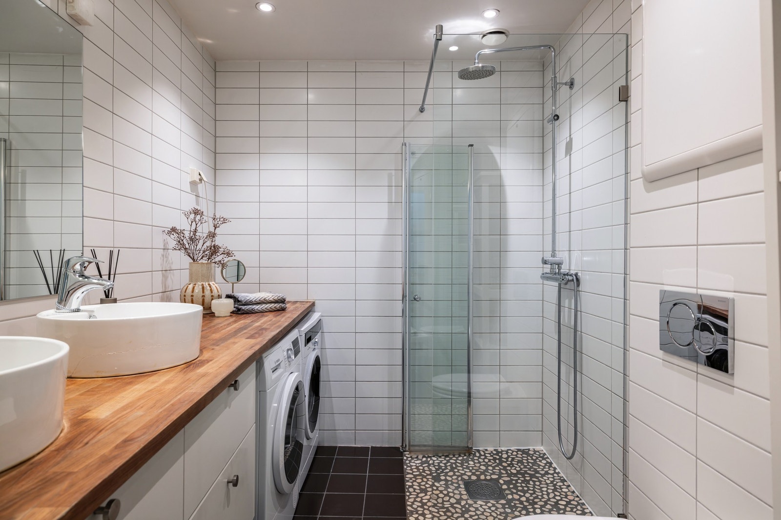 Av innredning er det en bred heltrebenkeplate med to toppmonterte, runde servanter, og under er det hvit skuffeseksjon, samt opplegg for vaskemaskin og tørketrommel. Galleribilde