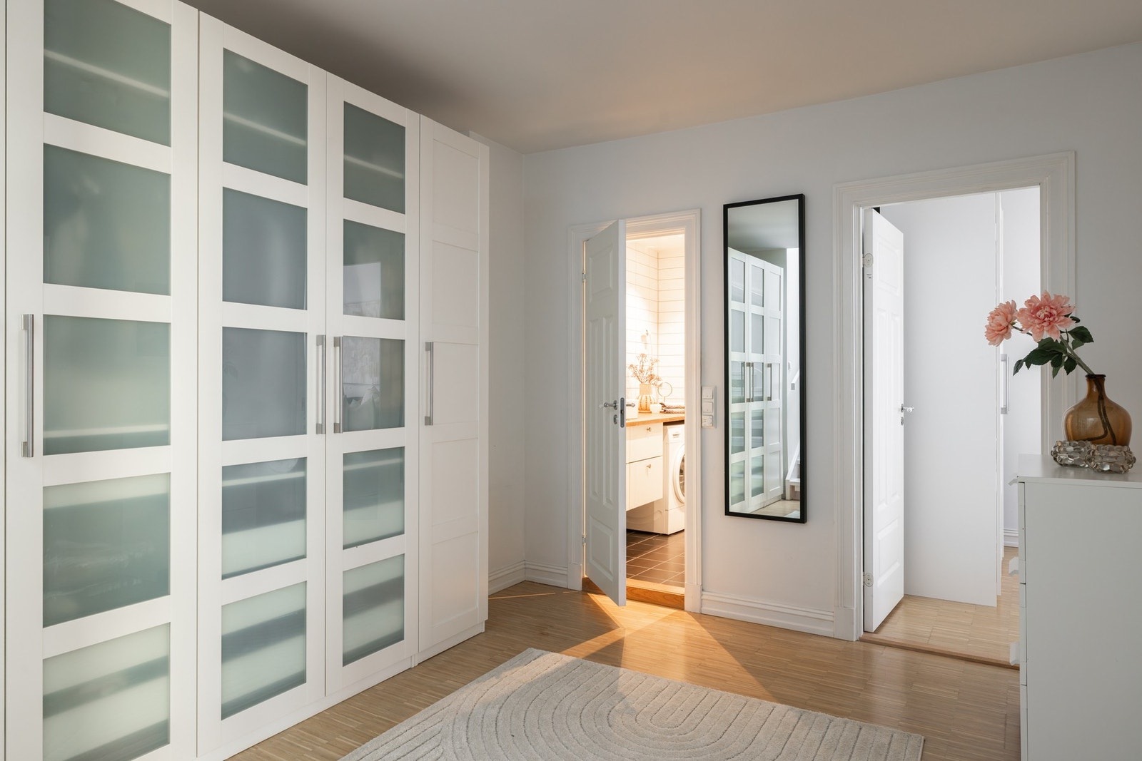 Her er det et romslig trapperom med adkomst til alle rommene i etasjen, og det er en bred rekke med garderobeskap for oppbevaring. Galleribilde